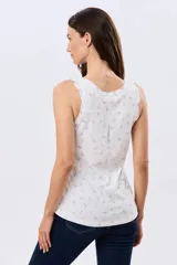 Musculosa de algodón blanca con pequeño estampado floral y volados en los tirantes, de corte clásico.