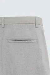 Pantalón de corte slim fit confeccionado en tejido elástico, con cintura elástica, cierre frontal con cremallera y botón, bolsillos laterales y bolsillos traseros de vivo.