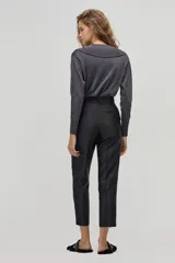 Pantalón sastrero negro de tiro alto con silueta tipo carrot. Tiene cintura ceñida con pliegues en el frente, bolsillos laterales y un bolsillo de ojal en la parte trasera. Confeccionado con taffeta.
