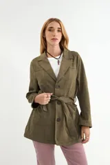 Chaqueta de gamuza sintética color bordó, con cuello solapa, cierre frontal de botones y cinturón ajustable del mismo material. Posee bolsillos frontales y mangas largas.