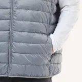 Chaleco acolchado ligero de cuello alto con cierre frontal de cremallera, diseñado con costuras horizontales.