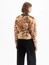 Buzo de rústico con estampado full print en tonos marrones y beige, cuello redondo tejido en color chocolate y puños y cintura tejidos en beige. De calce amplio y mangas largas.