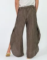Pantalón de lino amplio y fluido, con diseño de rayas verticales en tonos beige y marrón, cintura elástica y corte relajado.