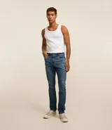 Pantalón de jean elastizado azul con lavado nevado, corte skinny y tiro medio.