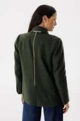 Blazer color verde oscuro con solapas con pespuntes blancos, de corte recto y cierre con un botón.