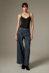 Body negro con tirantes finos, escote en V pronunciado y corte ajustado al cuerpo, con detalles bordados sutiles.