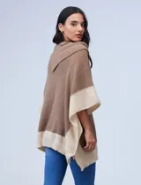 Poncho tejido colorblock, marrón y beige, con cuello vuelto asimétrico.