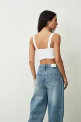 Top blanco de encaje con diseño estilo corsé, escote en V y tirantes anchos.