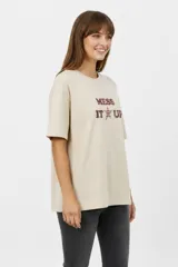 Remera oversize de algodón color beige, con cuello redondo, mangas cortas y estampa frontal con la frase "MESS IT UP" en tonos marrones.