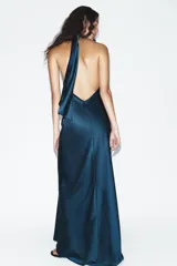 Vestido largo de satén verde oscuro con cuello halter y lazada en el mismo tejido en la parte posterior, diseño sin mangas y espalda descubierta.