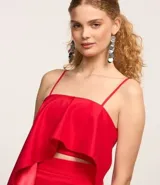 Blusa cropped roja de satén con breteles finos, escote cuadrado, lastex en la espalda y volado asimétrico.