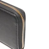 Billetera tipo clutch negra de material sintético (PU) con cierre perimetral metálico. Presenta un aplique rectangular con el logo XL en metal dorado en el frente.