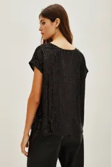 Remera azul marino con lentejuelas verticales, cuello redondo y mangas cortas.