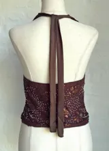 Top marrón con lentejuelas plateadas, escote halter y espalda descubierta.