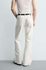 Jeans flare fit de tiro medio, confeccionados en denim de algodón color azul con efecto deslavado. Diseño ajustado en la parte superior y abierto en campana desde la rodilla, con cinco bolsillos y cierre frontal con cremallera y botón.