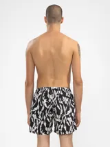 Short de baño negro con estampado de sirenas y plantas acuáticas en blanco. Tiene cintura elástica con cordón ajustable, bolsillos laterales y bolsillo trasero con cierre. Incluye suspensor de malla fina hipoalergénico.