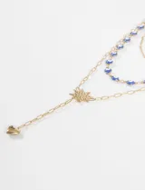 Collar tipo cascada de acero quirúrgico compuesto por dos cadenas, una con cuentas de ojitos turcos azules y otra con un dije central en forma de estrella y un dije inferior en forma de corazón.