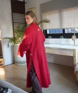 Tapado largo color verde con solapas, bolsillos laterales y cierre con botones.