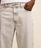 Pantalon de jean gris con lavado deslavado, de corte baggy y silueta holgada. Cuenta con bolsillos al frente y atras, y cierre de boton y cremallera.