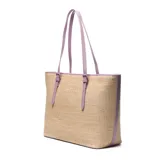 Cartera tipo tote de diseño estructurado, confeccionada con tejido efecto rafia en color beige y detalles de cuero sintético en tono lila. Cuenta con asas largas de hombro ajustables con hebillas y una pequeña placa metálica con el logo de la marca en el frente.