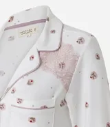 Camisón estilo americano de manga larga, confeccionado en tejido suave con estampado floral pequeño. Presenta cuello en V, cierre frontal abotonado, bolsillo en el pecho y detalles de encaje en los puños y hombros.