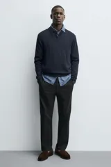 Mocasín de vestir para hombre, color marrón oscuro, fabricado en piel con acabado serraje (gamuza). Presenta un antifaz en el empeine con costuras visibles y suela a contraste con ligero tacón.