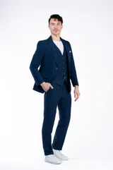 Ambo de corte comfort fit confeccionado en una mezcla de lino, viscosa y poliéster. El conjunto incluye un saco de dos botones con bolsillos laterales y un pantalón de corte recto, ofreciendo una textura suave y mayor resistencia a las arrugas que el lino tradicional.