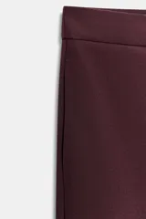 Pantalón de tiro alto con diseño tipo barrel, presenta pliegues frontales pronunciados, bolsillos laterales y cierre frontal con cremallera, botón interior y gancho metálico oculto.
