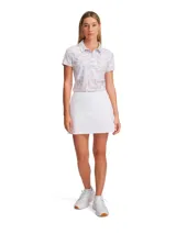 Pollera short deportiva de talle alto, color blanco, con diseño de pliegues en la parte trasera y pantalones cortos de compresión integrados. Incluye bolsillos laterales y tecnología de secado rápido.