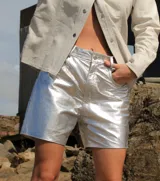 Short de cuero plateado con acabado metalizado y efecto arrugado, corte estilo jean de tiro medio y largo por encima de la rodilla.
