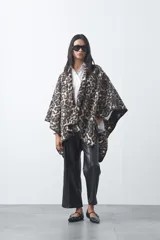 Poncho de silueta amplia con estampado animal print, bordes terminados con costura decorativa y diseño envolvente.