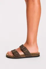 Sandalia plana de color tostado con diseño de tiras cruzadas y doble tira superior con hebillas metálicas ajustables, plantilla estilo corcho y suela negra.
