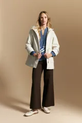 Camisa de manga larga color blanco, con cuello mao y escote en V. Presenta frunces en el canesú, cierre frontal con botones y mangas amplias con puños abotonados.