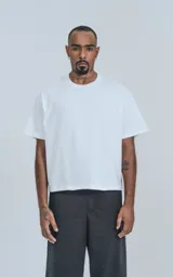 Remera de corte boxy con silueta amplia y recta, confeccionada en algodón premium. Presenta cuello redondo y mangas cortas con un calce relajado.