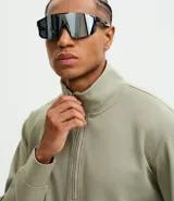 Buzo de cuello alto con cierre frontal parcial, manga larga y puños ajustados. Presenta un diseño minimalista en color verde militar.