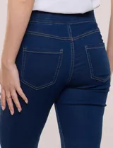 Jegging de denim azul oscuro con tiro medio-alto, cintura elástica ancha y pierna sutilmente entallada con terminación bootcut. Cuenta con bolsillos delanteros simulados y bolsillos aplicados en la parte trasera.