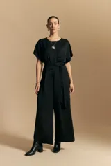 Pantalón negro de tiro alto, corte ancho y fluido, con pinzas en la cintura y cinto incorporado.