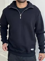 Buzo negro de felpa con cuello alto y cierre metálico plateado.