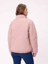 Campera puffer reversible de la marca Rusty, con diseño capitoneado. Presenta cuello alto, cierre frontal completo y logo bordado en el pecho. El interior es de un tono contrastante.