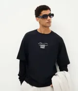 Remera de manga larga y corte boxy, color negro, con cuello redondo y estampa gráfica minimalista frontal con el texto "Master Desorder".