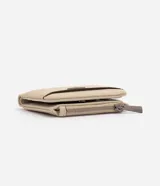 Billetera pequeña tipo sobre Satinato, color beige, confeccionada en poliuretano con textura símil cuero. Cuenta con cierre de cremallera superior, compartimento exterior para tarjetas y aplicación metálica triangular con el logo de la marca en el frente.