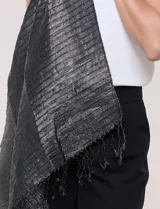 Pashmina gris metalizada de caída fluida, con hilos que crean un patrón de líneas horizontales y flecos finos en los extremos.