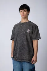 Remera de corte semi-oversize en color naranja con efecto de lavado tipo snow. Presenta un pequeño estampado gráfico en el pecho y cuello redondo.