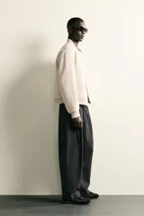 Pantalón de corte balloon fit confeccionado en tejido con viscosa. Presenta cintura ajustable con cinturón integrado, pliegues frontales, bolsillos laterales y bolsillos traseros de doble vivo. Cierre frontal con cremallera y botón.