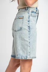 Bermuda de denim de tiro medio en color celeste claro lavado, corte recto y largo midi, con cinco bolsillos y cierre frontal con botón y cremallera.