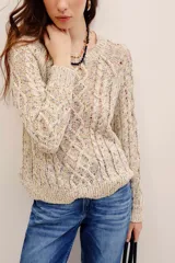 Sweater tejido de punto color beige con motas multicolor, cuello redondo y diseño de trenzas, de manga larga.