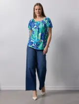 Blusa de seda fría con estampado floral en tonos azules y verdes. Cuello redondo con frunce y mangas cortas amplias con terminación fruncida.