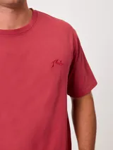 Remera negra de corte suelto y mangas cortas, con pequeño bordado a tono en el pecho.