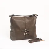 Cartera de hombro color verde oliva, con textura granulada y paneles laterales en gamuza. Presenta dos correas decorativas frontales con hebillas metálicas y cierre superior. Incluye una correa larga extraíble y regulable.