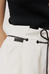 Short blanco de tiro alto, confeccionado en lino, con bolsillos laterales y cordón ajustable en la cintura.